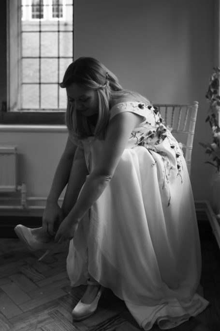 Bride putting on shoes with floral dress